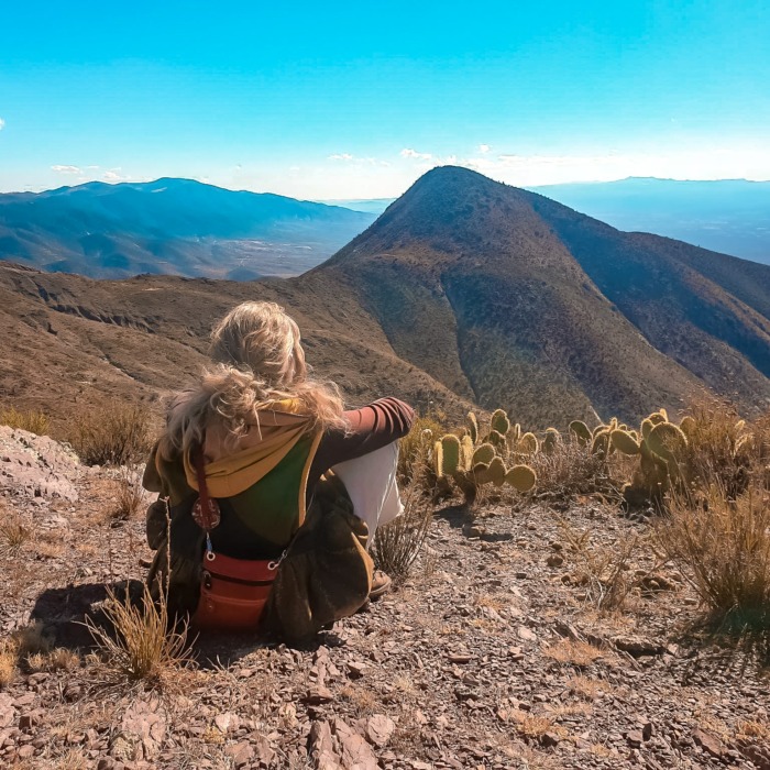 Lalitha assise sur la montagne face à l'horizon