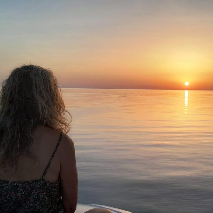 Lalitha devant l'horizon et le soleil couchant sur la mer